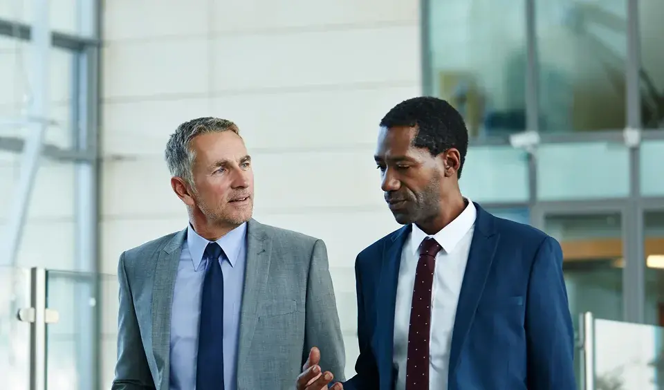 two colleagues walking in office lobby